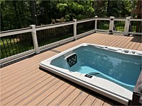 <b>Trex composite deck boards in the color of Tiki Torch with a Lava Rock feature board.  The railing is white PVC vinyl with a Lava Rock drink rail and black aluminum balusters.  Matching gate at the steps. Eyeball post lights on the railing to light up the space during the evening hours.  Hot tub on deck is sunken into the deck</b>